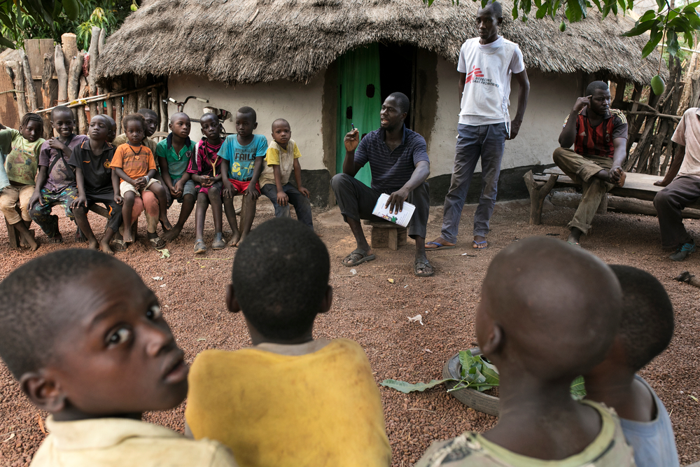 Sekouba Souare, a community health worker trained by MSF, reaches out to villagers in Kakidi, Guinea.