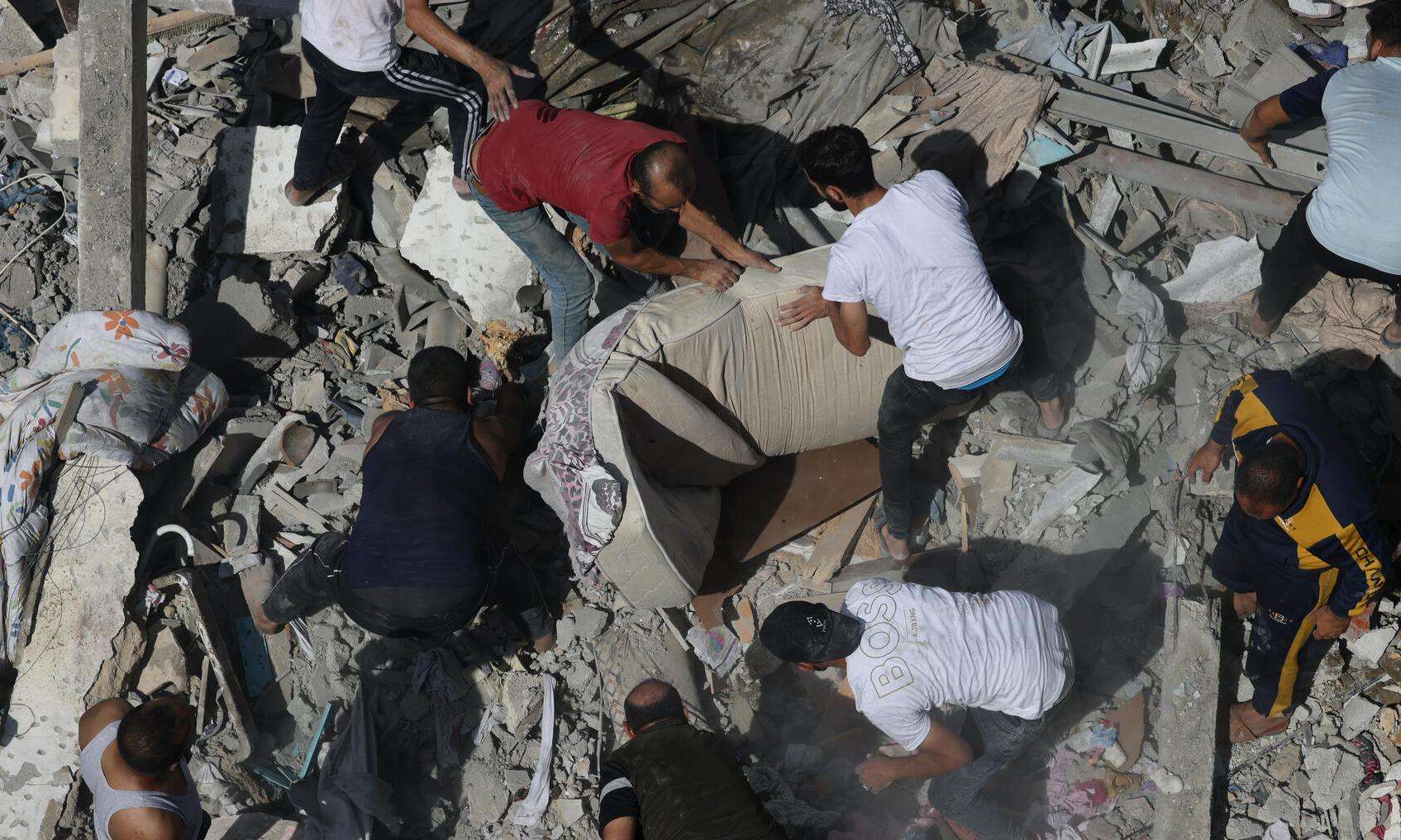 Palestinians search for survivors in the rubble left by an Israeli airstrike on Gaza in October 2023.