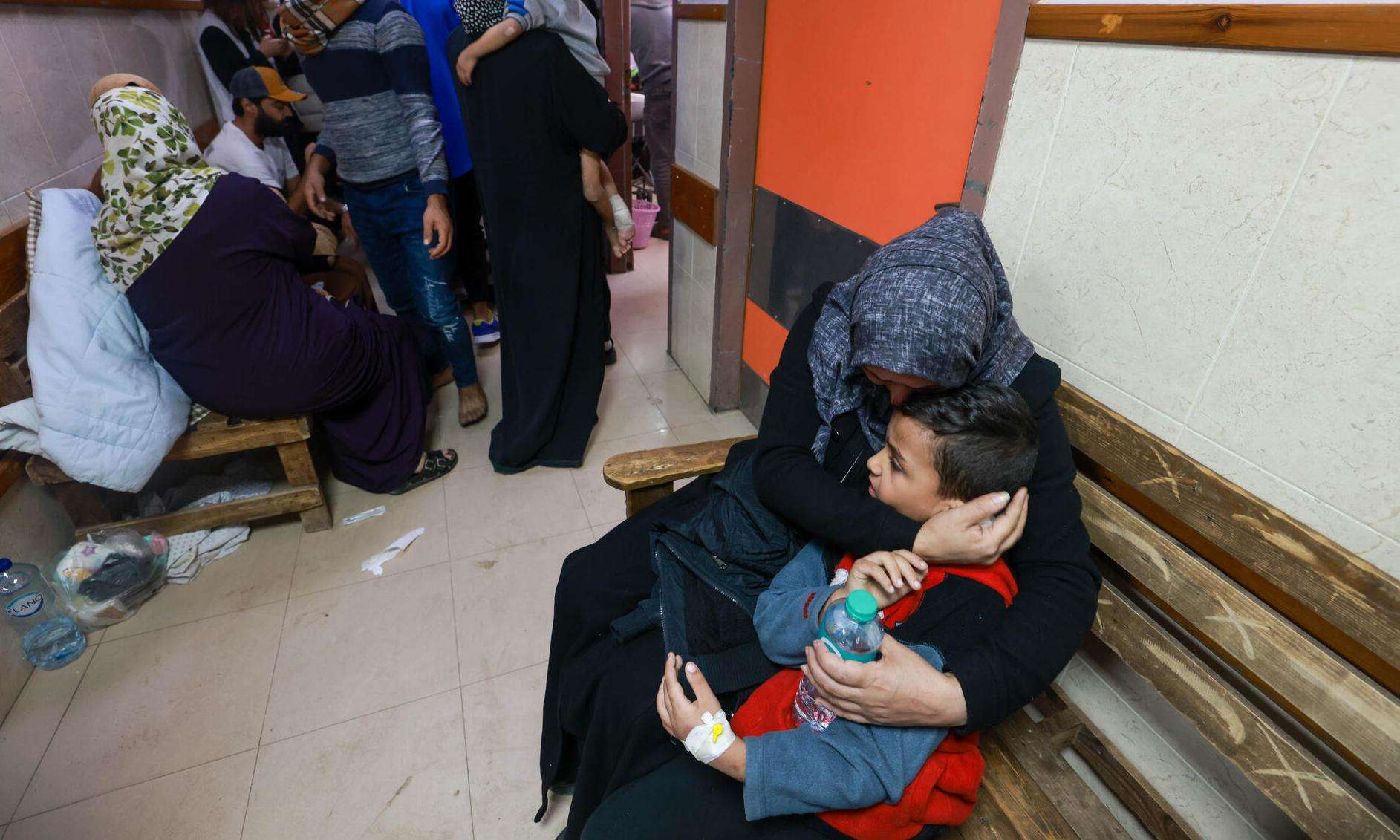 A mother hugs her child in a crowded hallway at Al Aqsa Hospital in Gaza