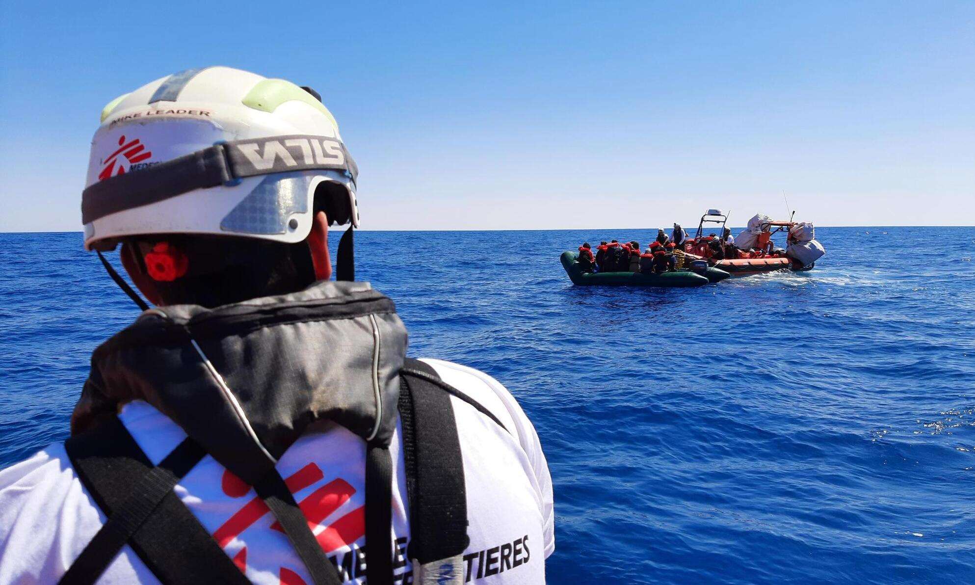 An MSF search and rescue staff member approaches a boat in distress in the Mediterranean.
