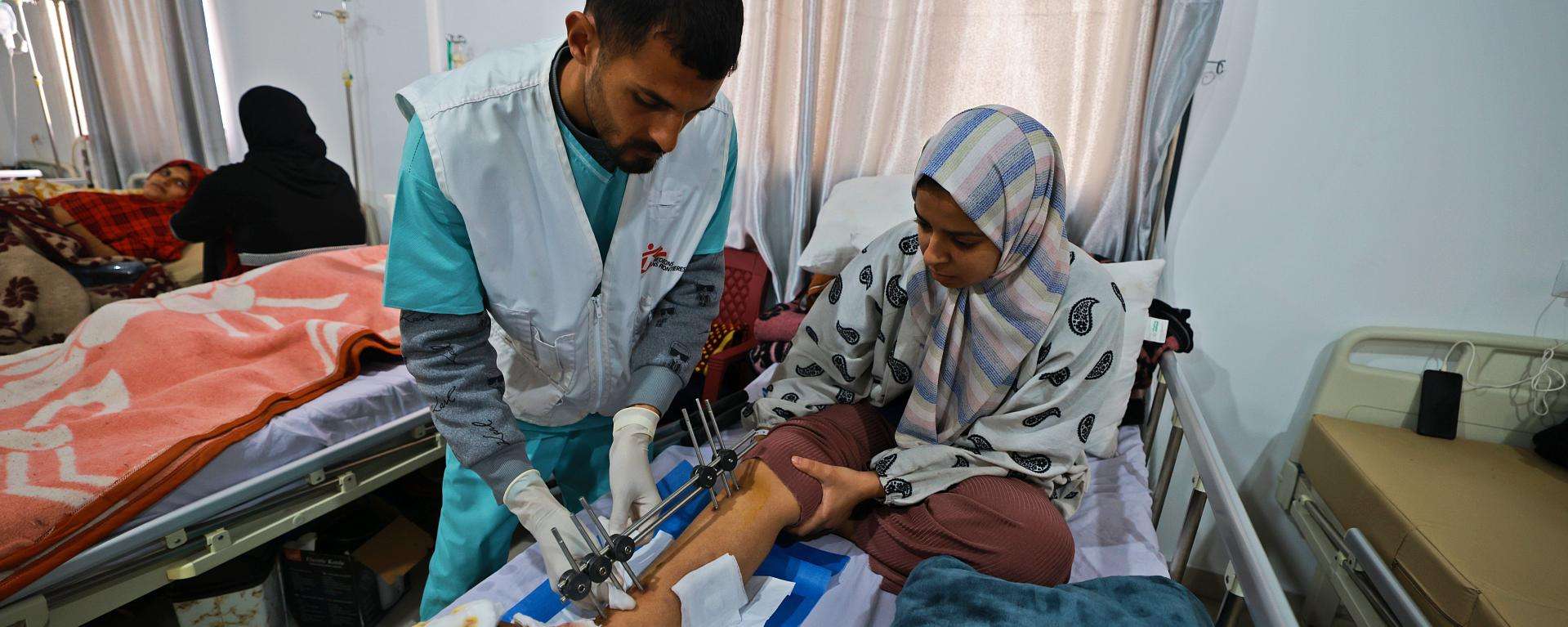 An MSF staff member treats the injured leg of a woman at Rafah Indonesian Field Hospital in Gaza.