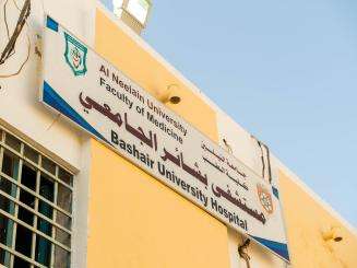 Outside Bashair Teaching Hospital in Khartoum, Sudan, where a sign hangs on the side of the building.