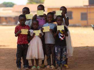 Children proudly show their vaccination cards in Yambio during the targeted campaign in Western Equatoria state.