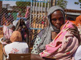 A displaced woman holding her child in Zamzam camp, North Darfur, Sudan.