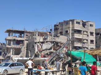 Palestinians in Rafah look at a destroyed building. 