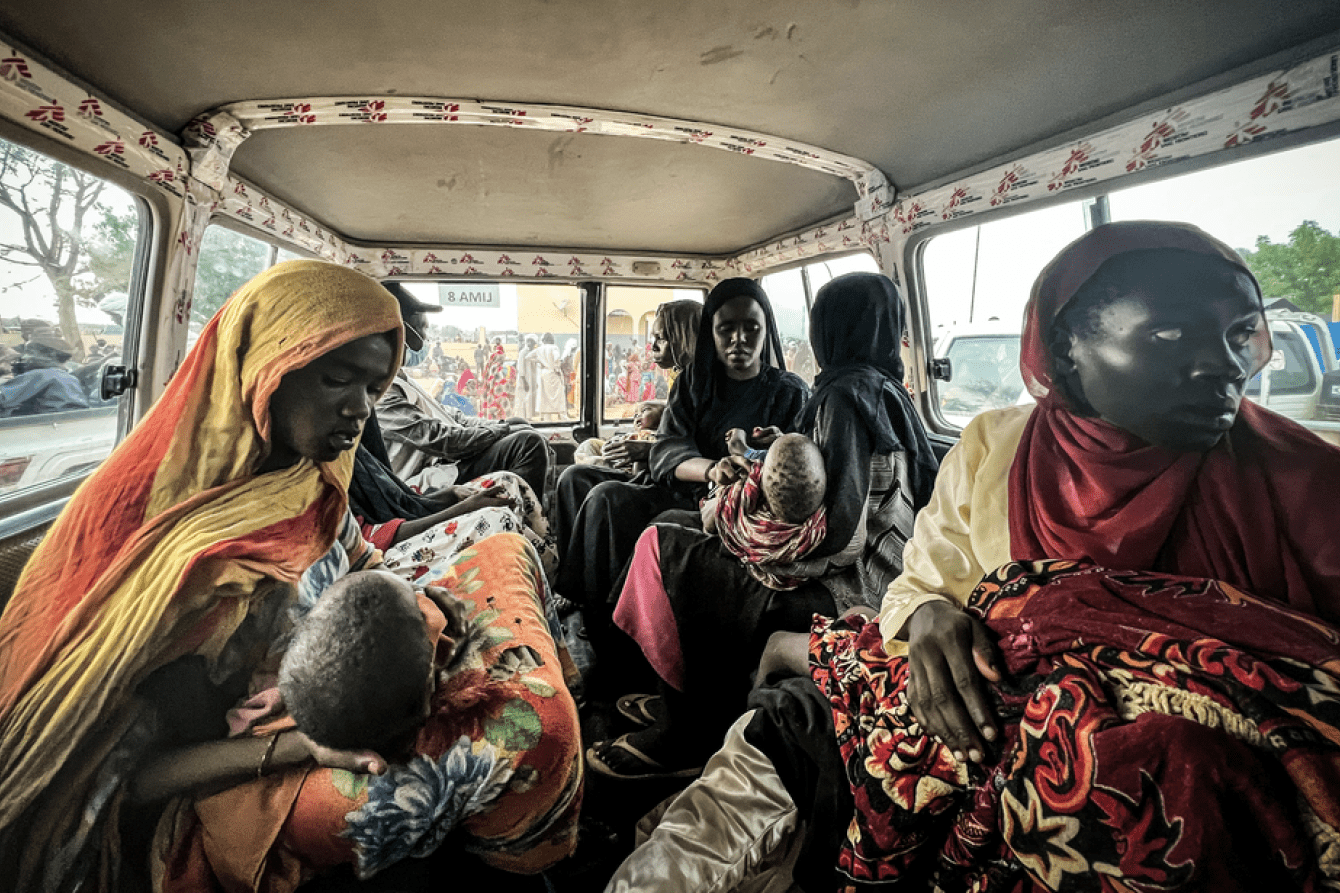Women and children from Sudan inside a bus arriving in a refugee camp in Chad.