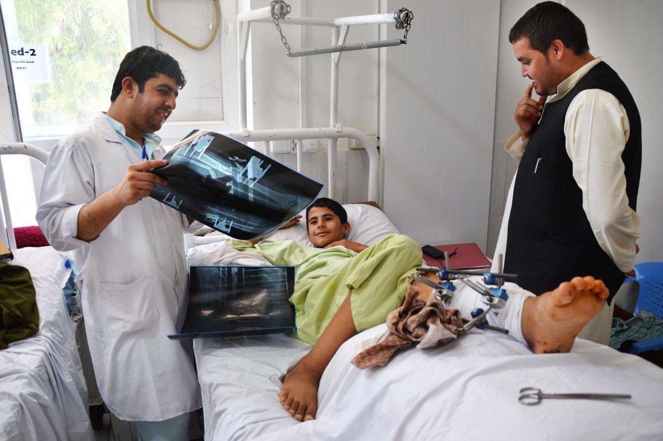 MSF physiotherapist looks over x-rays with a 14-year old patient at Boost hospital in Lashka Ghar, Helmand province, Afghanistan.  
