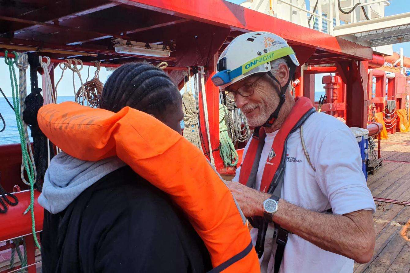 Medical Team Leader, Stefanie, helps rescued people remove their life jackets as they come on board Ocean Viking.