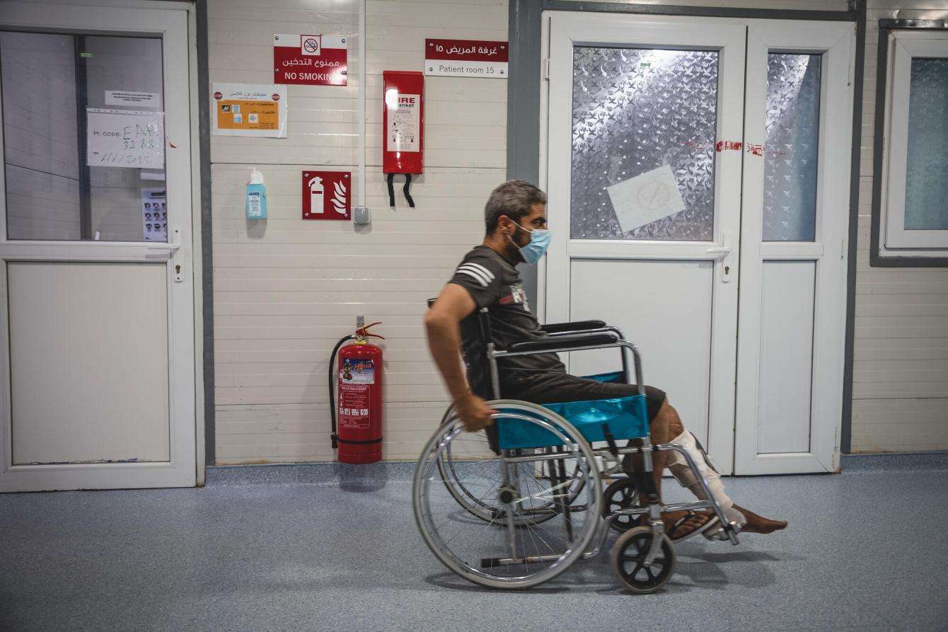 A patient uses a wheelchair to go through a hospital corridor in Mosul, Iraq. 