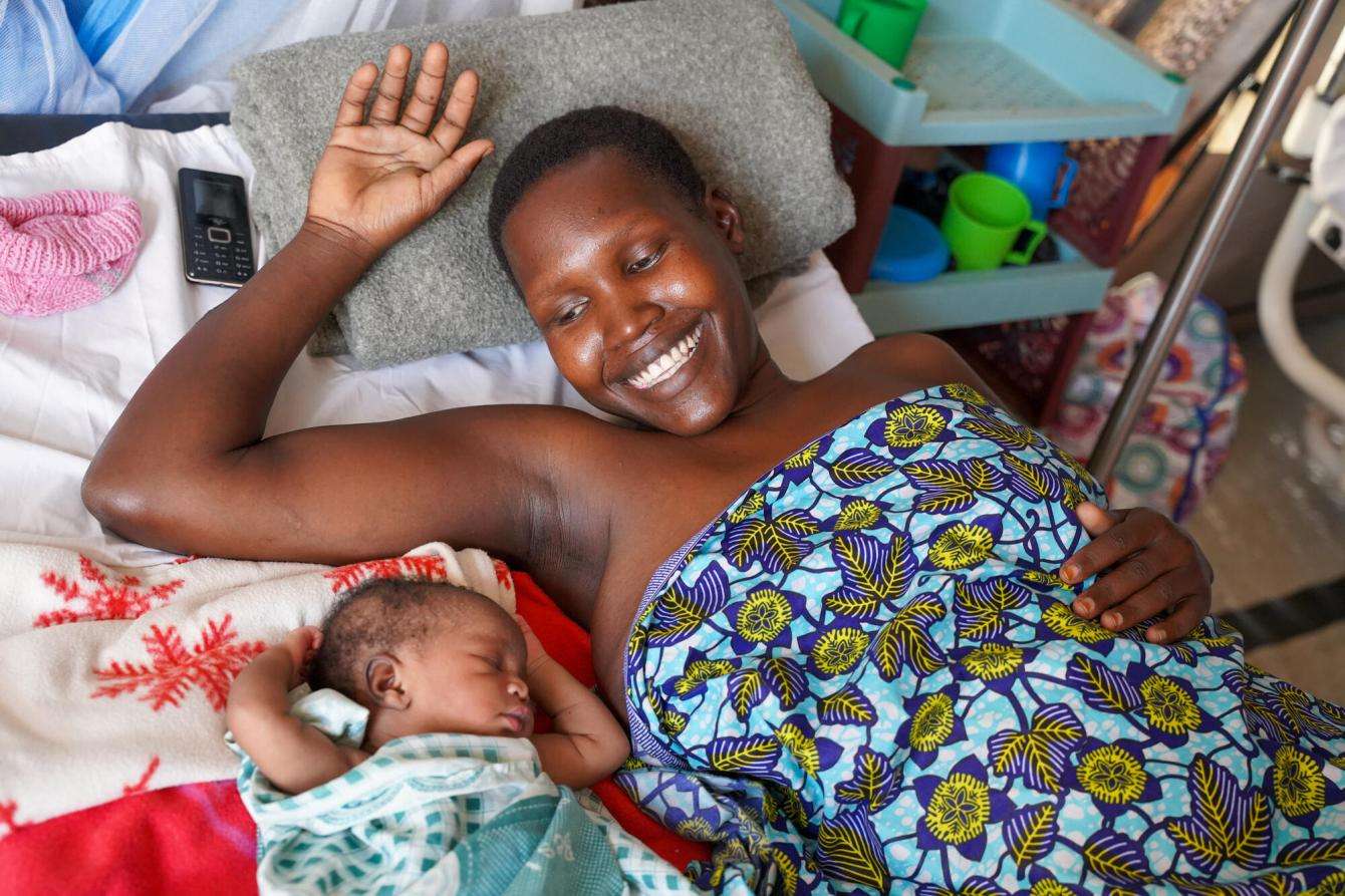 A woman smiles looking at her baby in Kajo Keji, South Sudan.