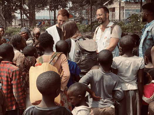 Residents of a displacement camp near Goma, DRC gather around MSF Missing Maps survey team 