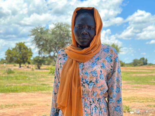 Fisal Ibriahim Silman stands with her son outside the Wedweil refugee settlement in Northern Bahr El Ghazal, South Sudan