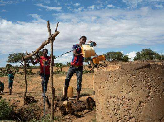 A young man fetches water from a well in the desert of Madagascar.