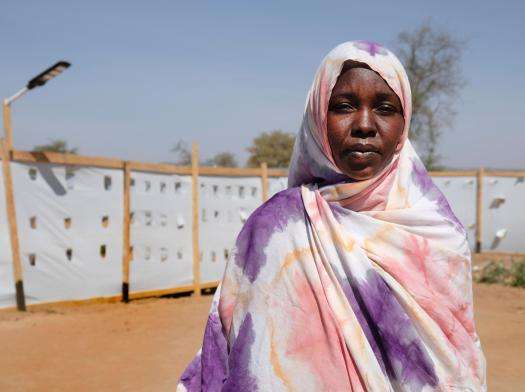 A woman in a pink and purple scarf at Metche camp for Sudanese refugees and returnees in Chad.