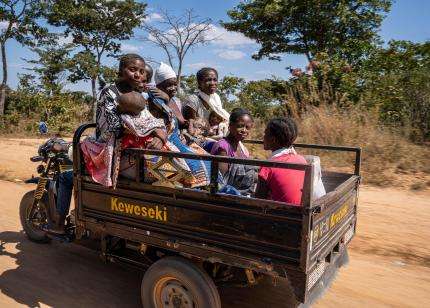 People travel in the bed of a truck to reach health care in Huila province, Angola.