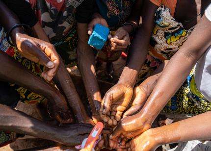 A group of women wash hands before MSF consultations in Angola.
