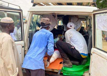 MSF emergency teams help wounded Sudanese refugee out of an ambulance in Chad